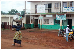 Woman carrying bowls on her head.