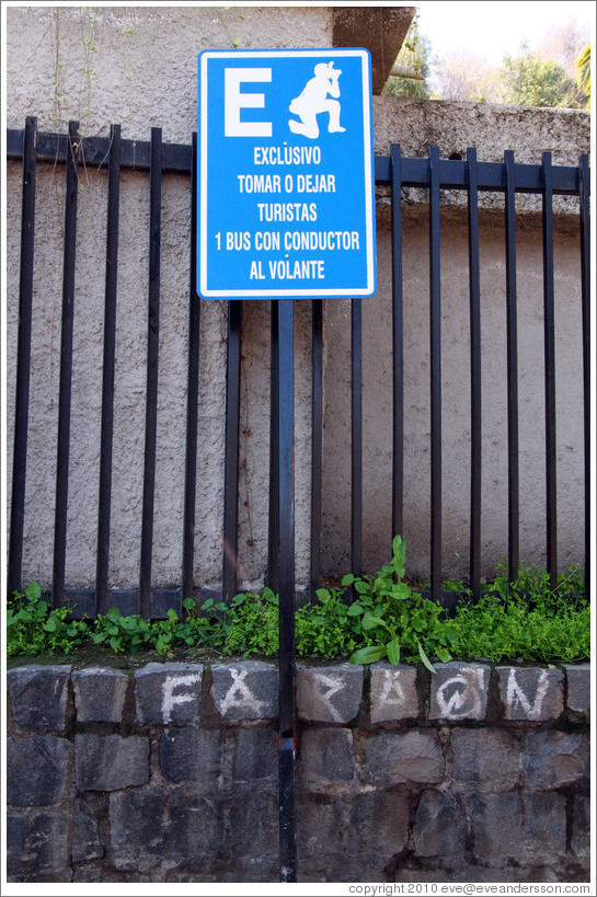 Sign depicting a tourist as someone kneeling with a camera.  Constituci?Bellavista.