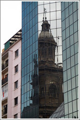 A tower of the Cathedral Metropolitana reflected in a modern building, Plaza de Armas.