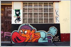 Graffiti: feline woman riding a bicycle and porcine man farting.  Dardignac, Bellavista neighborhood.