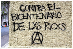 Graffiti: Contra el Bicentenario de Lxs Ricxs.  (Against the Bicentennial of the rich.)  For some reason, the Os have been replaced with Xs in "Los Ricos" in this and other graffiti in the city.  San Mart? city center.