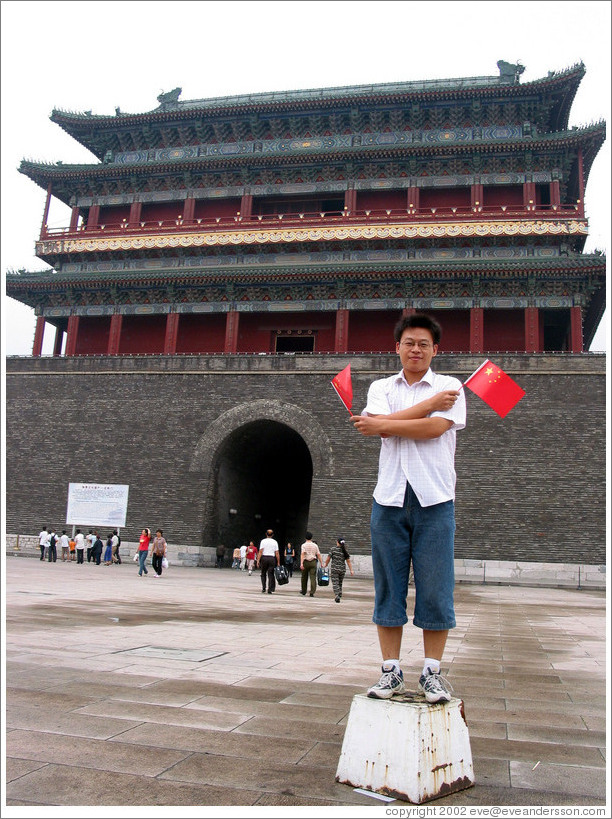 Young man holding Chinese flags (he was posing for me).  Tiananmen Square.