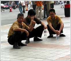 Men squatting.  Wangfujing Ave.