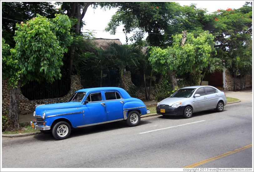 Old, blue car, with grey Hyundai.