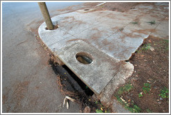 Hole in the sidewalk.