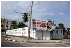 On Avenida de la Independencia, a wall painted with "Unidos, Vigilantes, y Combativos" ("United, Vigilant, and Combative"), "8 Congreso" ("8th Congress"), "En cada barrio" ("In every neighborhood"), and "CDR" (Committees for the Defense of the Revolution); and a billboard with Jos&eacute; Mart&iacute; next to the words "Uno de los hombres m&aacute;s l&uacute;cidos y &uacute;tiles de Cuba" ("One of the most lucid and useful men of Cuba"), "Aniversario 116 de su ca&iacute;da en combate" ("116th anniversary of his death in combat"), and "Aniversario 23 de la Operaci&oacute;n Tributo" ("23rd anniversary of the Operation Tribute").