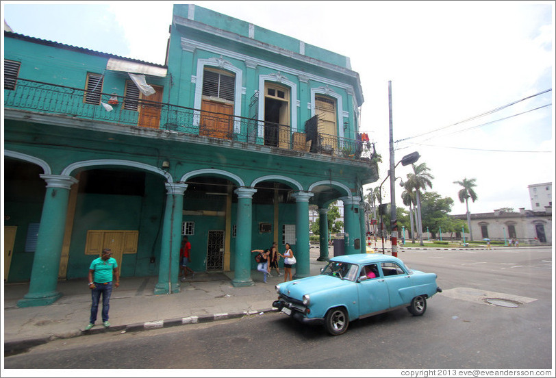 Blue car in front of a green building, Avenida Simon Bolivar (Calle Reina).