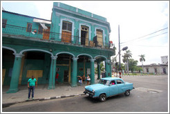 Blue car in front of a green building, Avenida Simon Bolivar (Calle Reina).