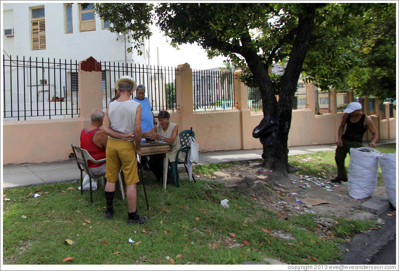 Men playing a board game outside, 25th Street.
