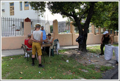 Men playing a board game outside, 25th Street.