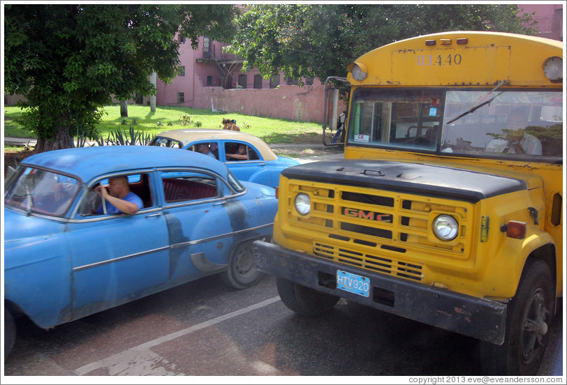 Blue cars and a repurposed school bus (now carrying adult passengers), corner of Calle Avenida de M&eacute;xico Cristina and Calzada 10 de Octubre.