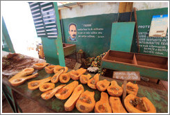 Market with fly-covered open fruit and a picture of Jos&eacute; Mart&iacute; on the wall.