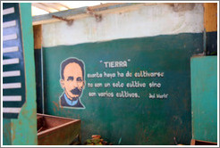 Market wall with a picture of Jos&eacute; Mart&iacute; and the words "Tierra" ("Earth"), and "Cuanta haya ha de cultivarse no con un solo cultivo sino con varios cultivos" ("How much must be cultivated not with one crop but with multiple crops").