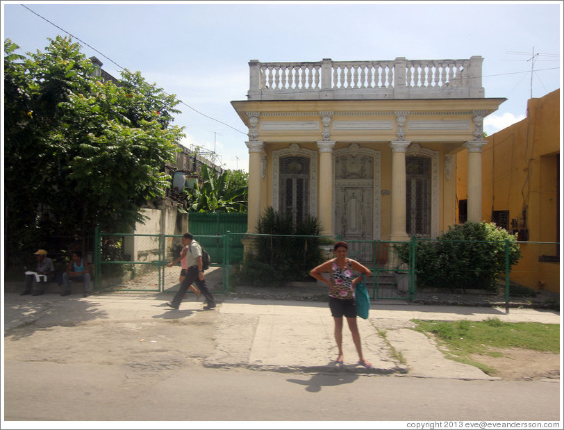 Woman in front of a yellow building, Calzada 10 de Octubre.