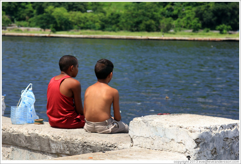 Two boys sitting on the Malec&oacute;n.