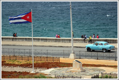 Cuban flag and a blue car on the Malec&oacute;n.