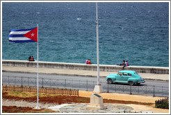 Cuban flag and a blue car on the Malec&oacute;n.