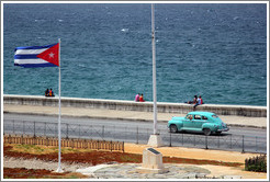 Cuban flag and a blue car on the Malec&oacute;n.