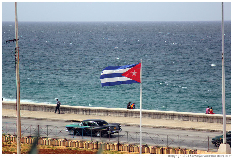 Cuban flag and a green and black car on the Malec&oacute;n.