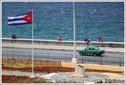 Cuban flag and a green car on the Malec&oacute;n.