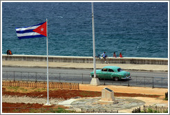 Cuban flag and a green car on the Malec&oacute;n.