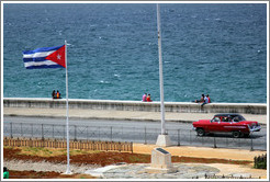 Cuban flag and a red car on the Malec&oacute;n.