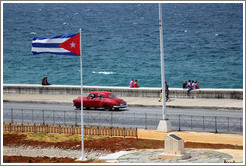 Cuban flag and a red car on the Malec&oacute;n.