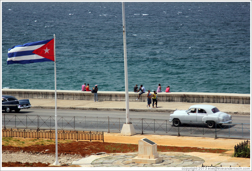 Cuban flag and a white car on the Malec&oacute;n.