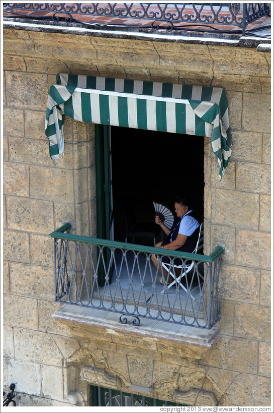 Woman with a fan in the window, Calle Obispo, Old Havana.