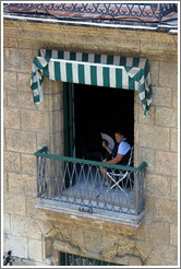 Woman with a fan in the window, Calle Obispo, Old Havana.