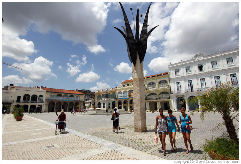 Three women passing a flower sculpture, Plaza Vieja, Old Havana.
