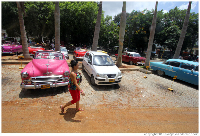 Woman walking past a hot pink car, Paseo del Prado.