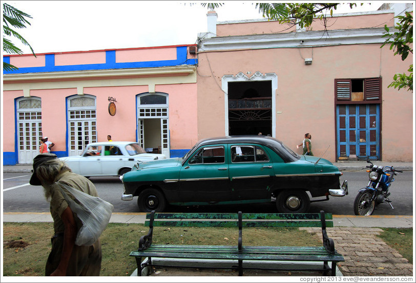 Homeless man and dark green car, near Parque de la Libertad (Liberty Park).