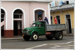 Truck with people standing in it passing Teatro Velasco, near Parque de la Libertad (Liberty Park).