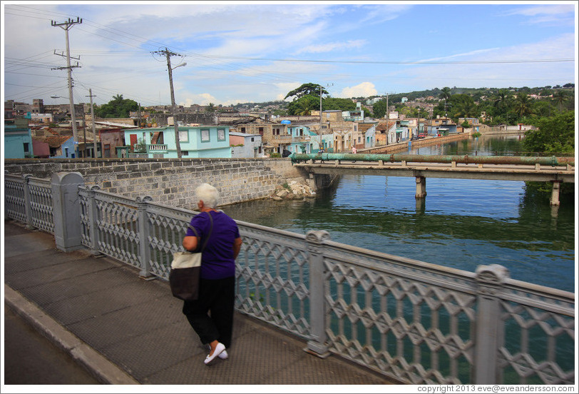 Lady crossing bridge over Rio Yumuri.