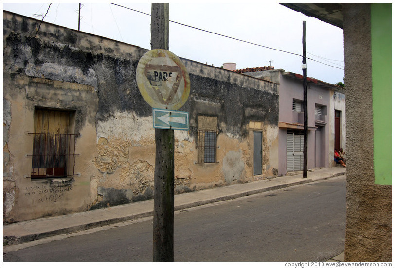 Stop sign ("Pare"). Under the window, someone has written, "Arroje la basura en su casa, no en la m&iacute;a / El Due&ntilde;o" ("Throw away garbage in your house, not mine / The Owner").