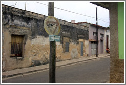 Stop sign ("Pare"). Under the window, someone has written, "Arroje la basura en su casa, no en la m&iacute;a / El Due&ntilde;o" ("Throw away garbage in your house, not mine / The Owner").