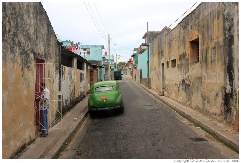 Street with green car.