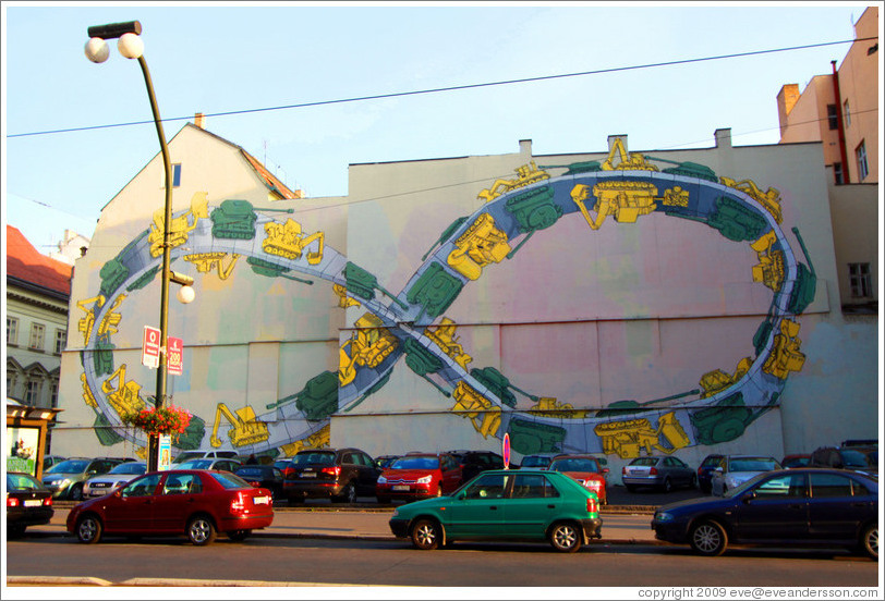 Wall painted with a giant M?bius strip, with alternating tanks and tractors driving on it.  N?dn?Nov?&#283;sto.