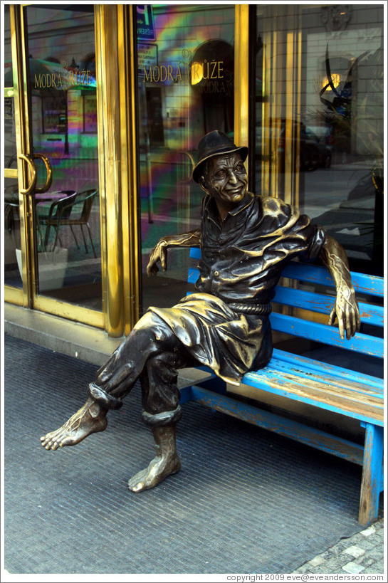 Sculpture of a barefoot man sitting, in front of the Modr?&#367;?e (Blue Rose) hotel, Ryt?345;sk?Star?&#283;sto.