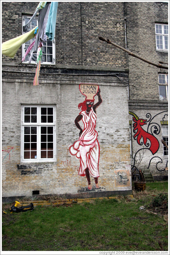 House with painting of a woman carrying a jug that reads "human justice" on her head.