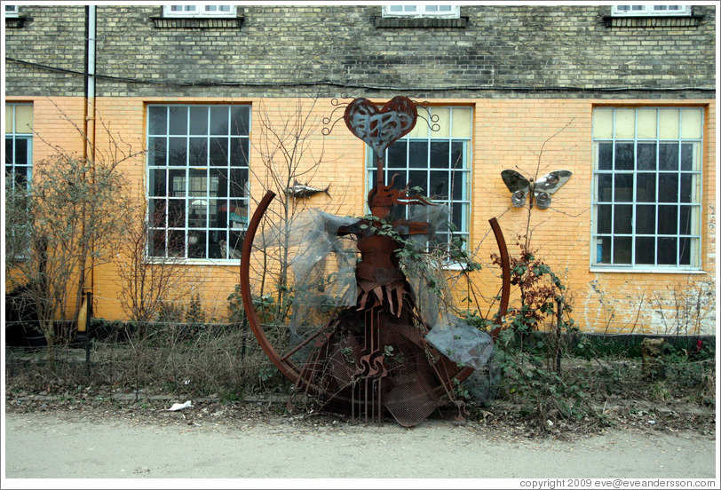 Metal sculpture of a woman with a heart above her head.