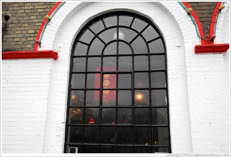 Window of the Moonfisher Cafe, with the Christiania flag hanging behind it.