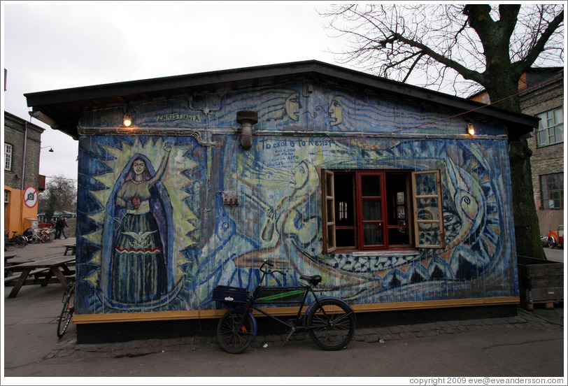 House painted with a strong female figure and "To exist is to Resist".