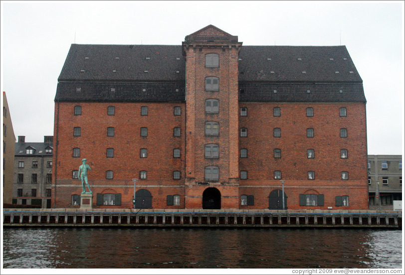Vestindisk Pakhus, a restored warehouse overlooking Copenhagen harbour.  In front of it stands a replica of Michelangelo's David.