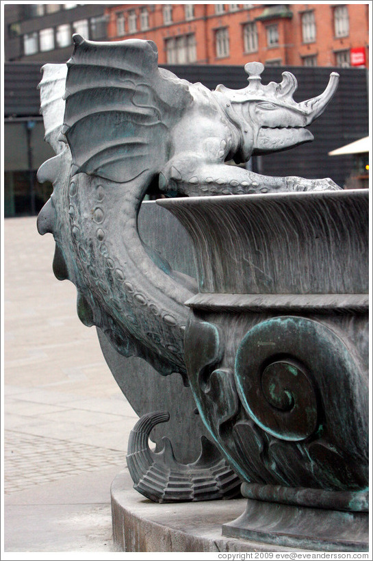 Dragon-like figure on fountain in front of R?us (Town Hall).