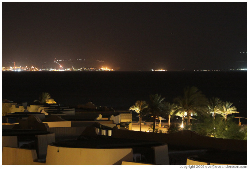 Marriott Hotel at night, with the lights of Jordan and Saudi Arabia in the background.  The border is at the barely-visible red dots in the middle of the right of the two nearly empty spaces.