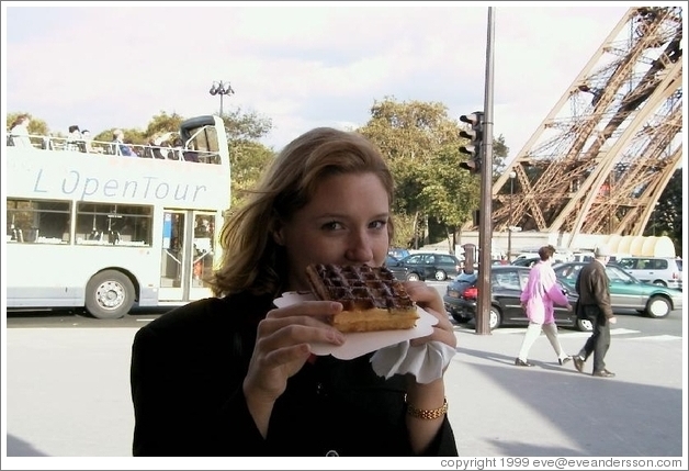Eve, enjoying a waffle with nutella, in front of the Eiffel Tower.