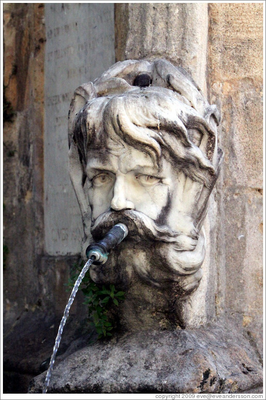 Face containing a water spout.  Fountain in the Place de l'H? de Ville (city hall plaza).