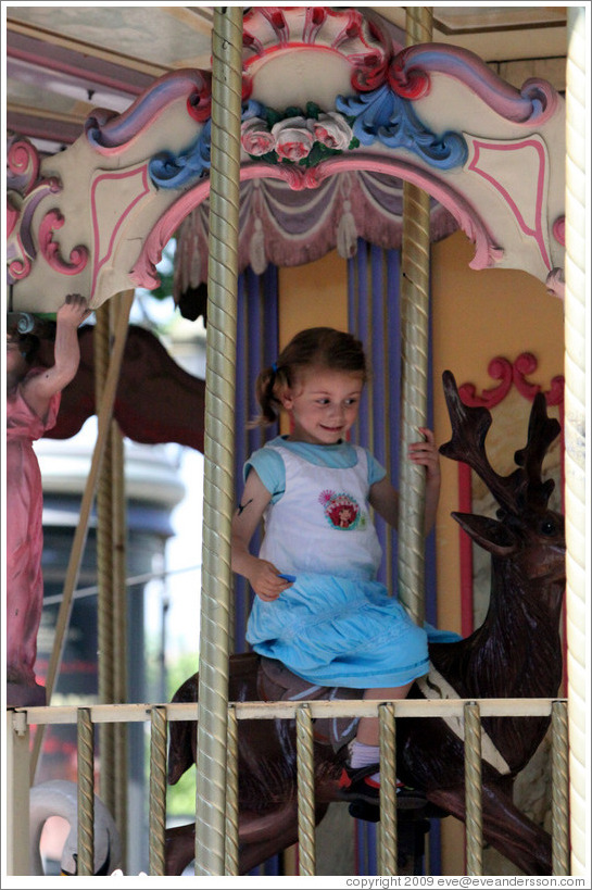 Girl on the merry-go-round.  Place de la Rotonde.